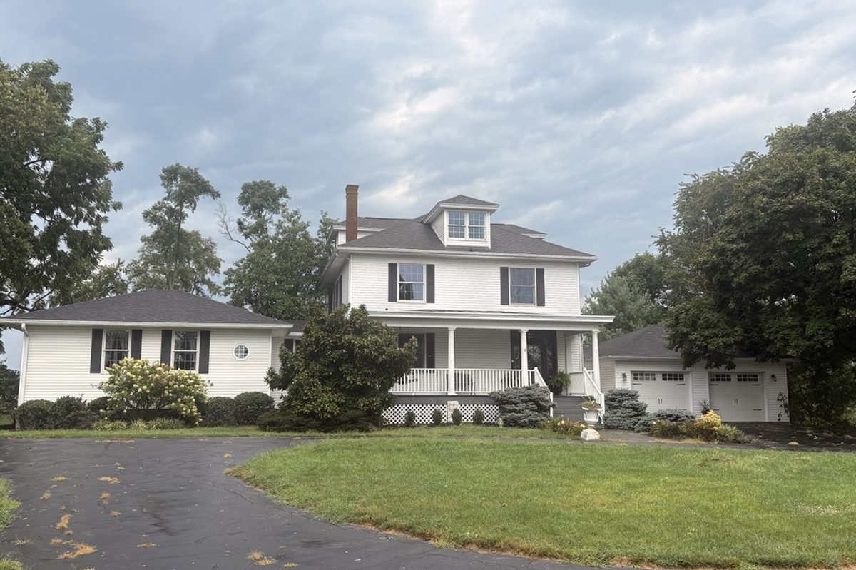 Suburban two-story home photographed in daylight — the daytime source photo uploaded to SellWorthy.